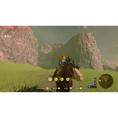 "In-game screenshot from The Legend of Zelda: Breath of the Wild – Nintendo Switch 2 Edition, showing Link riding Epona through a scenic landscape with mountains and lush greenery."
